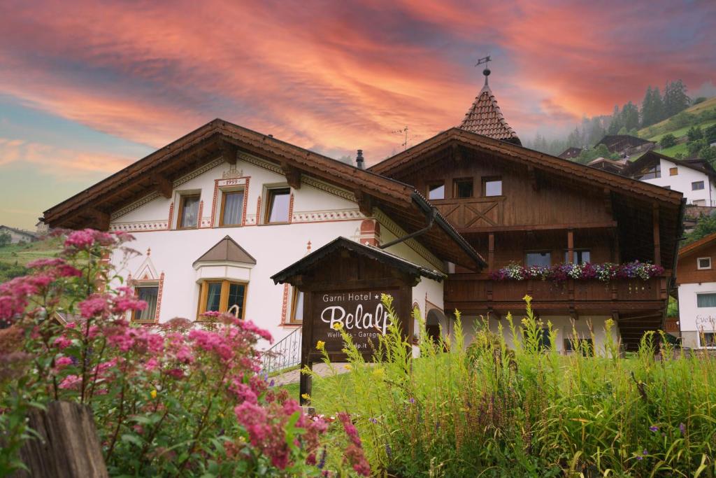 a house with a sign in front of it at Garni Hotel Belalp in Santa Cristina Gherdëina