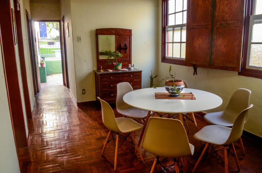 uma sala de jantar com uma mesa branca e cadeiras em - Casa Pitanga - Acomodação lindíssima pertinho da Igreja do Rosário em Ouro Preto