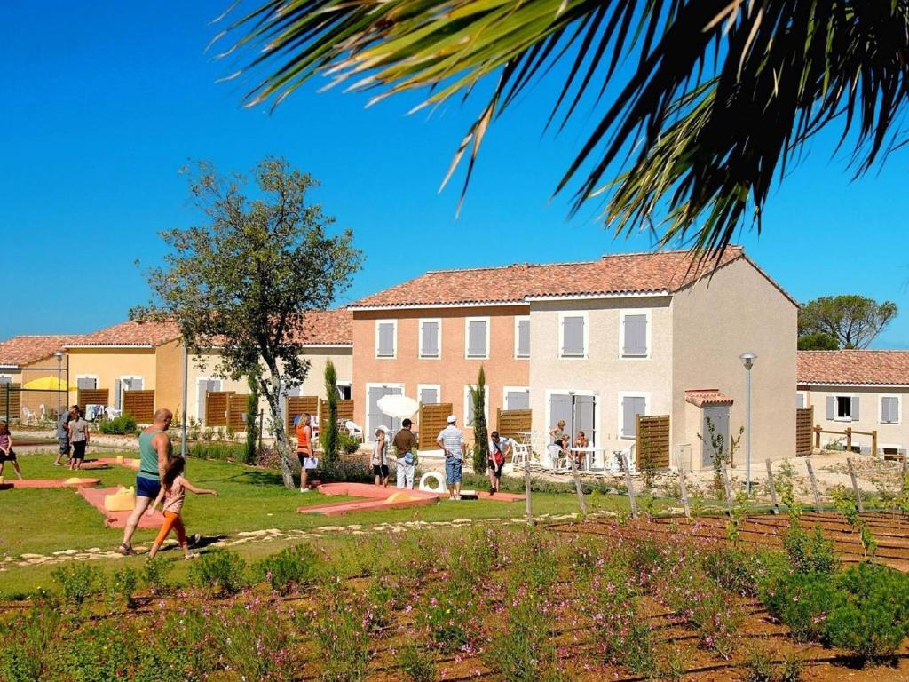 un groupe de personnes se promenant autour d'une cour avec un bâtiment dans l'établissement Well kept holiday home between Nimes and Montpellier, à Aubais