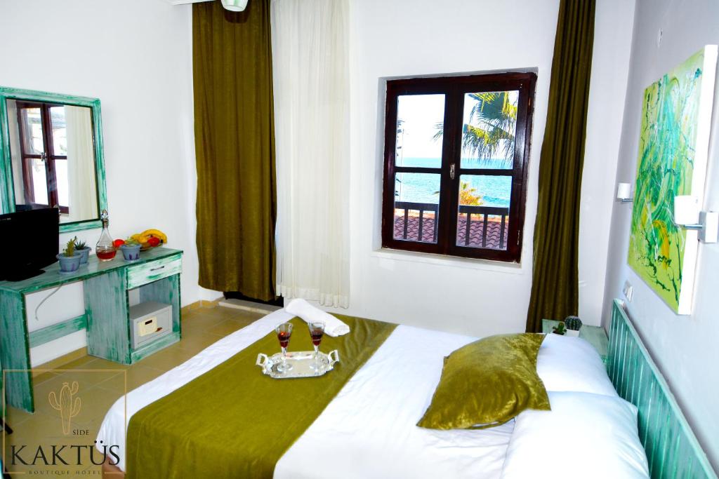 a bedroom with a bed with a green blanket at Side Kaktüs Boutique otel in Side