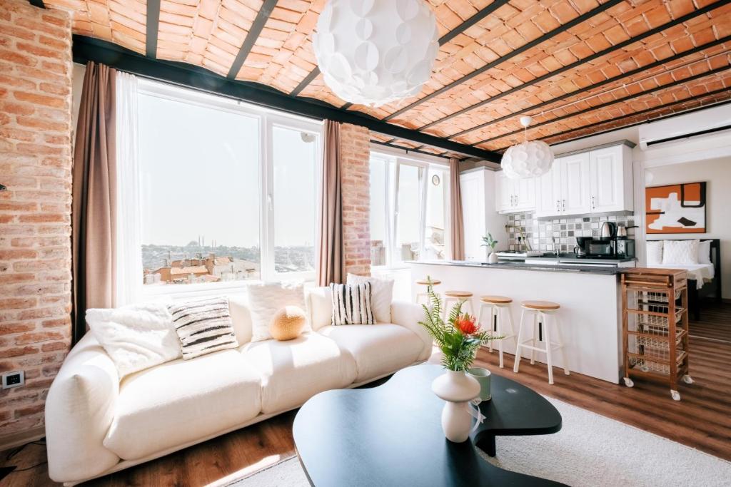 ein Wohnzimmer mit einem weißen Sofa und einem großen Fenster in der Unterkunft Flat w City View Near Galata Tower in Istiklal Ave in Istanbul