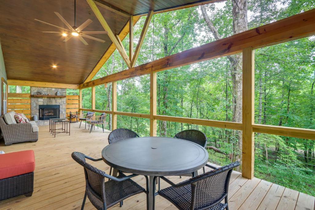 a screened in porch with a table and chairs at Blue Ridge Mountainside Cottage with Fire Pit! in Epworth