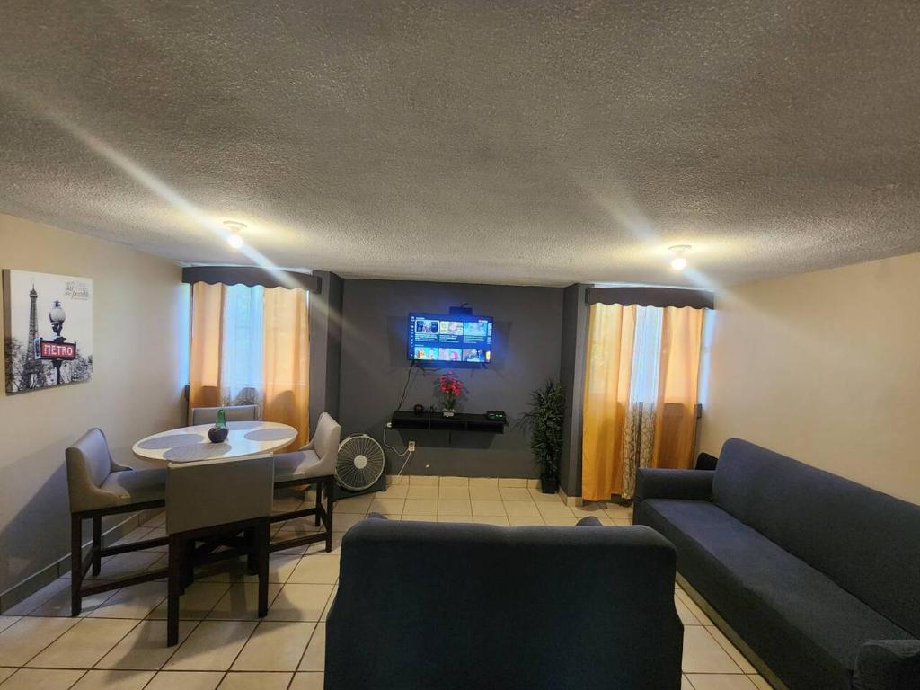 a living room with a couch and a table and a tv at Departamento 2 Recamaras 1 Baño Cocina y sala in Matamoros