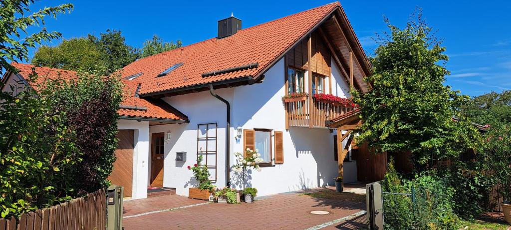 una casa blanca con techo naranja en Traumhafte Ferienwohnung auf 100 Quadratmetern für 6 Pers nähe München, ICM, Therme, MUC en Forstinning