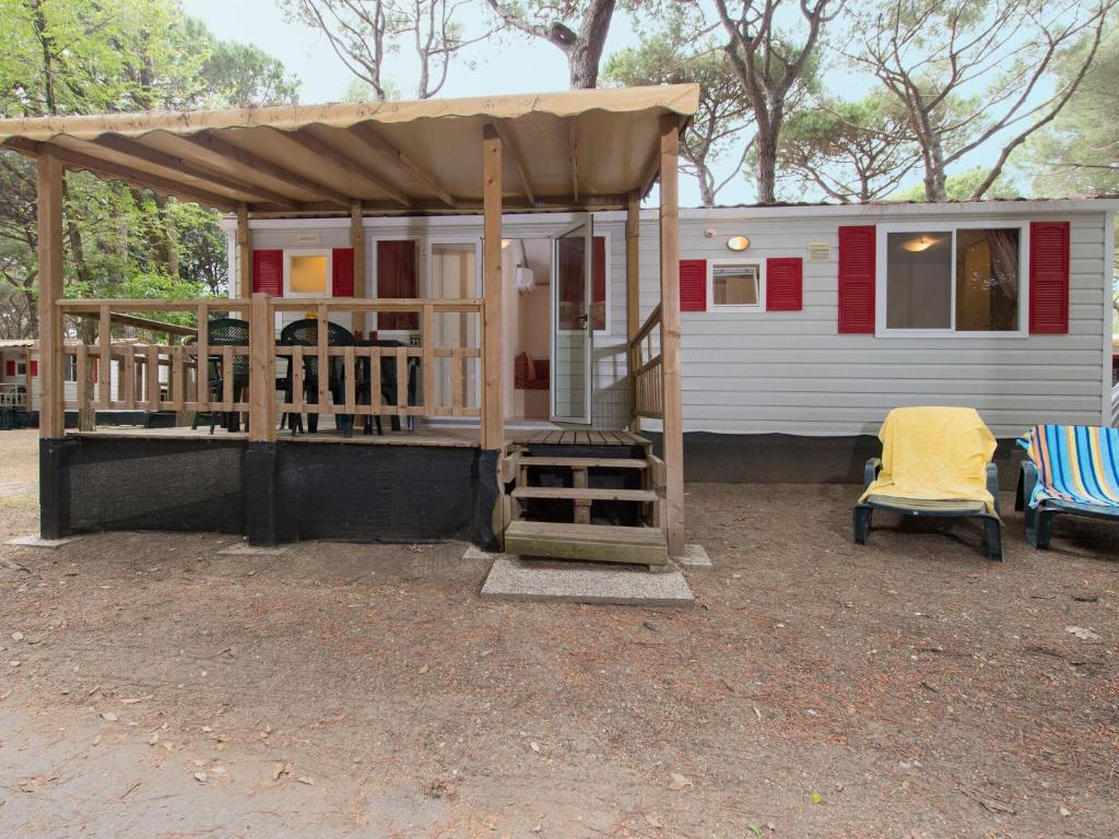 リド・ディ・スピーナにあるDetached mobile home with terrace near the sea on the Adriatic coastの小さな家 ポーチ&日よけ&椅子2脚付
