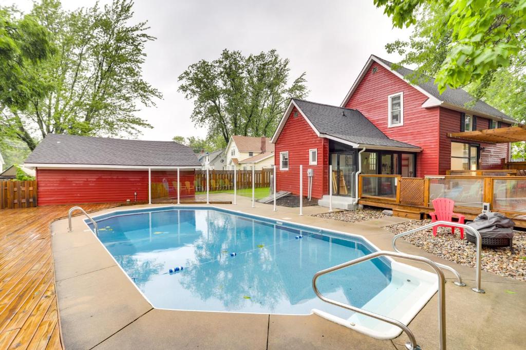 a swimming pool in front of a red house at South Haven Oasis - Private Hot Tub, Pool and Grill! in South Haven