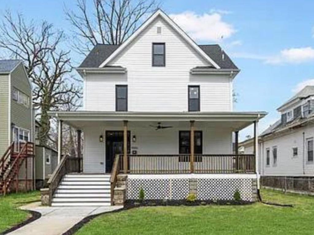 a white house with a front porch and stairs at 1 Bed 1 Bath Basement Apartment with Private Entrance in Baltimore