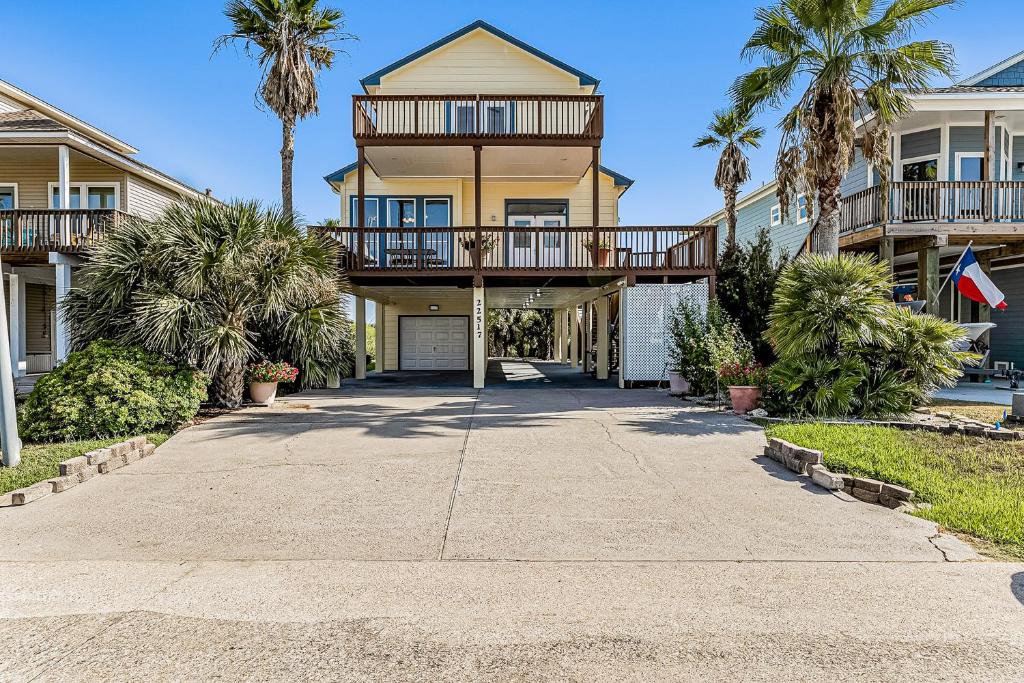 uma casa com palmeiras em frente a uma entrada em Isla Bonita em Galveston