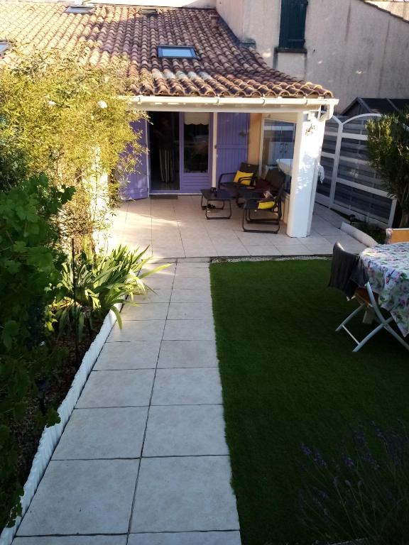 une cour avec une pelouse et une terrasse dans l'établissement F1 avec piscine dans résidence privée, à Bagnols-en-Forêt