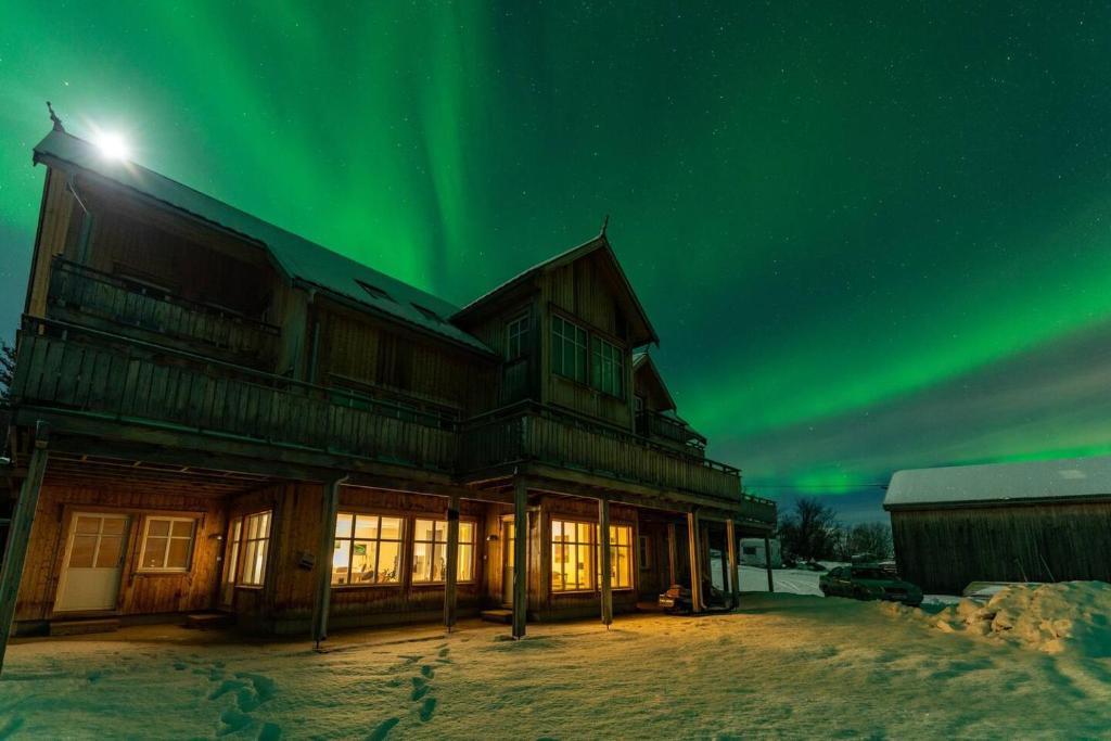 a house with the aurora in the sky at Amazing and secluded northern light apartment near sea and city! in Selnes