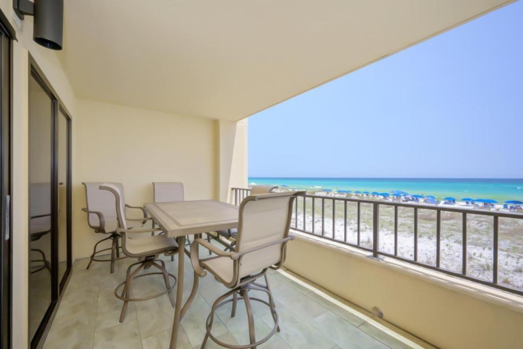 a balcony with a table and chairs and the beach at Surf Dweller 203 in Fort Walton Beach