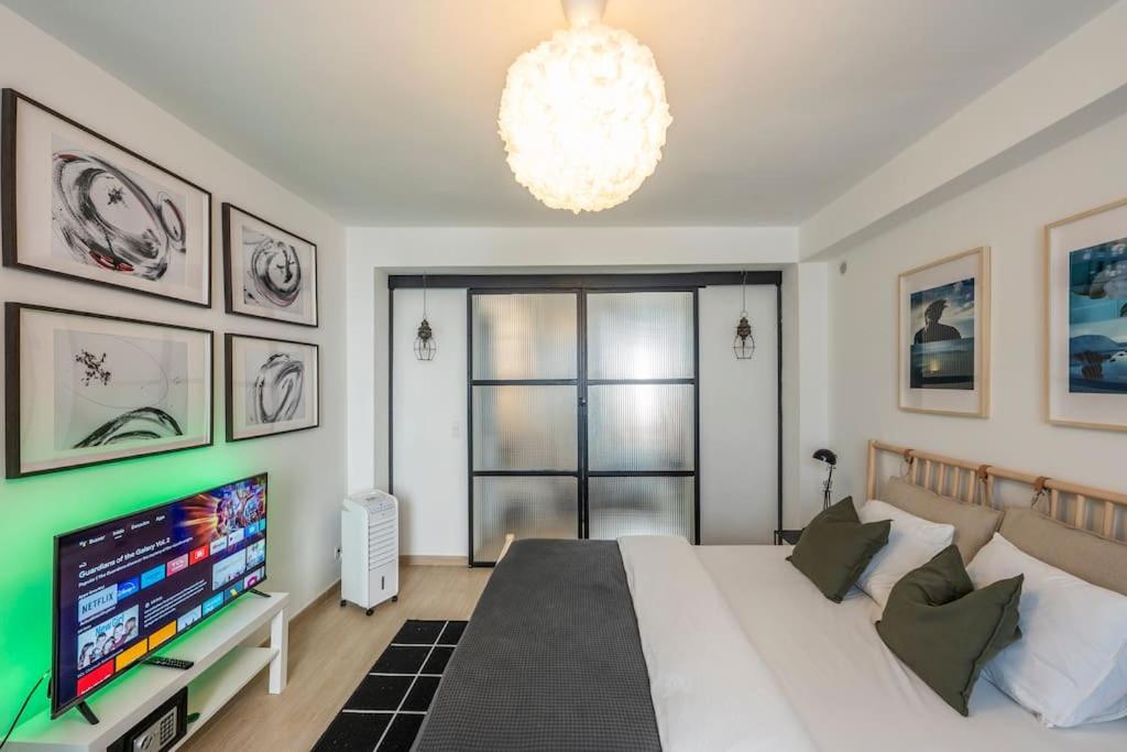 um quarto com uma cama grande e uma televisão em Superb 3 Bedroom & 3 Bathroom Duplex In Brussels City Centre em Bruxelas