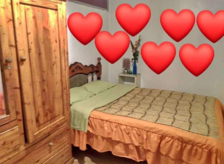 a bedroom with a bed with hearts on the wall at ESCOCIE-VA 1 in Quito