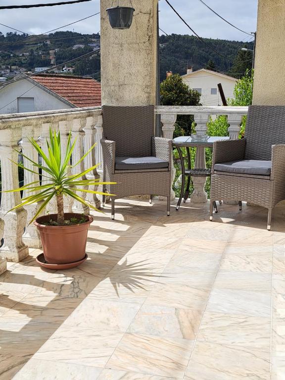 une terrasse avec des chaises, une table et une plante en pot dans l'établissement Casa Regina logement de 120m2, 
