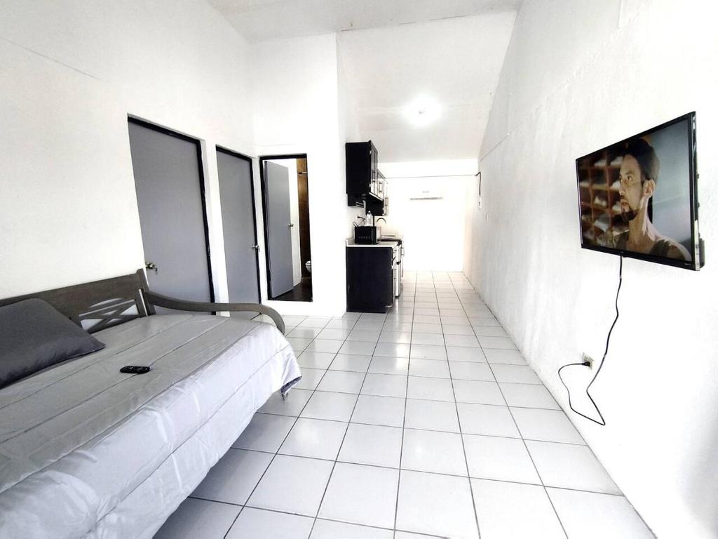 1 dormitorio con 1 cama y TV en la pared en Área Consulado y CAS 1 persona - D8, en Nuevo Laredo