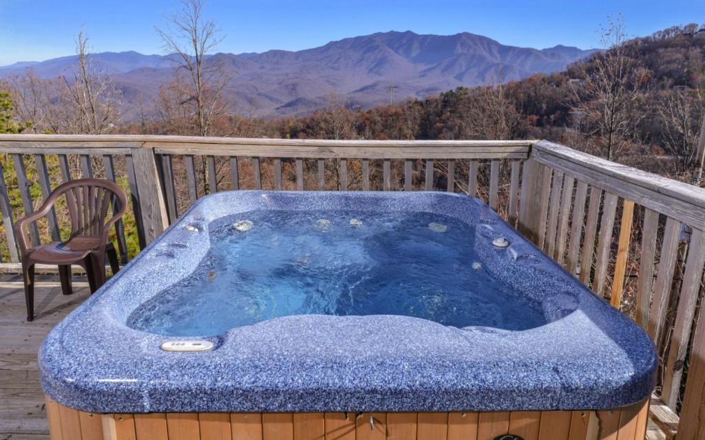 a jacuzzi tub on a deck with a view at Sky High in Gatlinburg