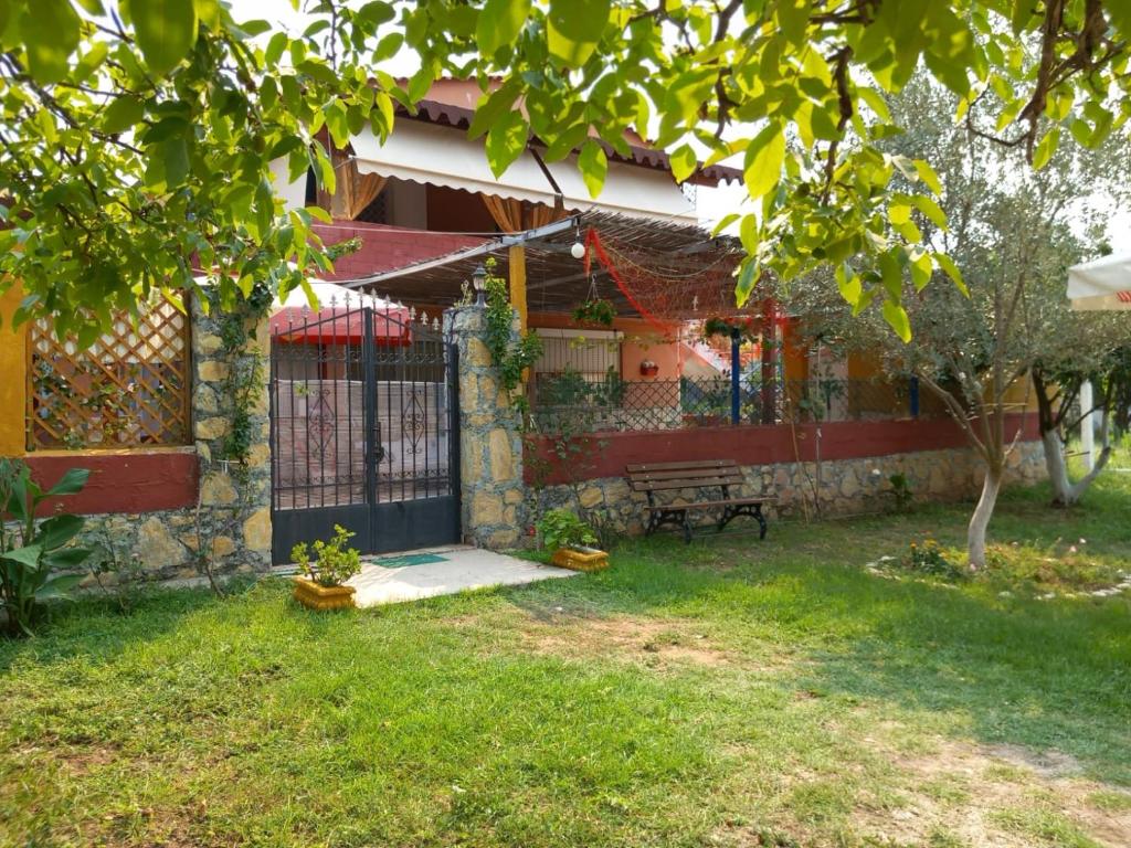 dom z bramą i ławką w ogródku w obiekcie Vila Gjoka w mieście Himara