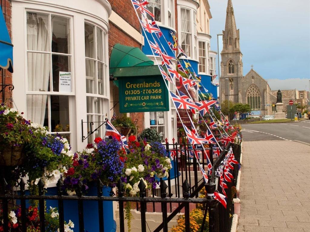Una valla con banderas británicas en el lateral de un edificio. en Greenlands Guest House, en Weymouth
