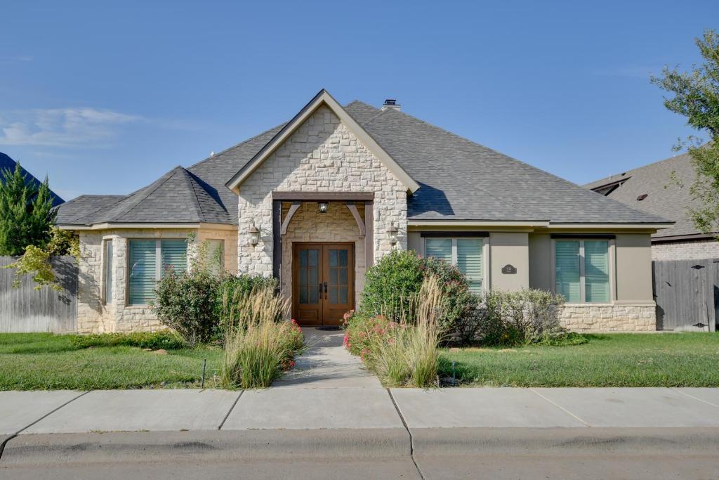 a house with a brown door on a street at Spacious Amarillo Home 6 Mi to Downtown! in Amarillo