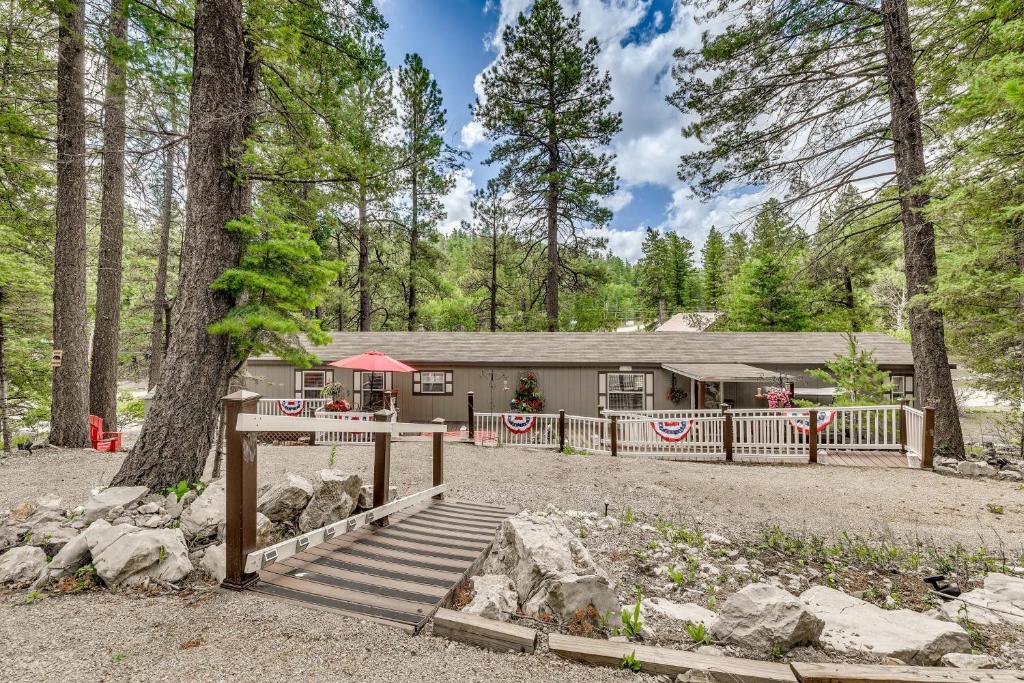 a house in the woods with a porch and a fence at Peaceful Cloudcroft Vacation Rental Walk to Shops in Cloudcroft