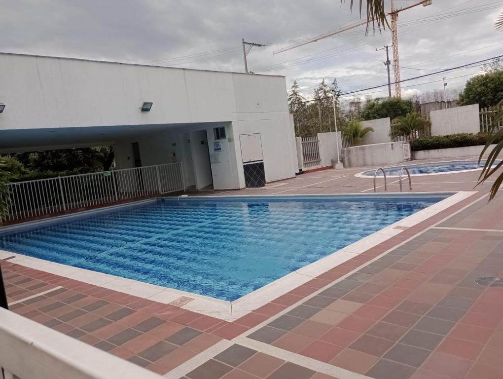 a swimming pool next to a white building at Apto Agradable y Fresco en Conjunto Cerrado Decimo Piso in Neiva