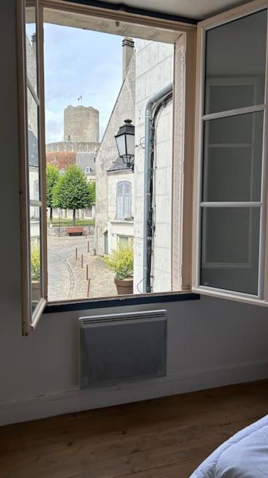 a bedroom with a window with a view of a street at Appartement cœur de ville in Châtillon-sur-Indre