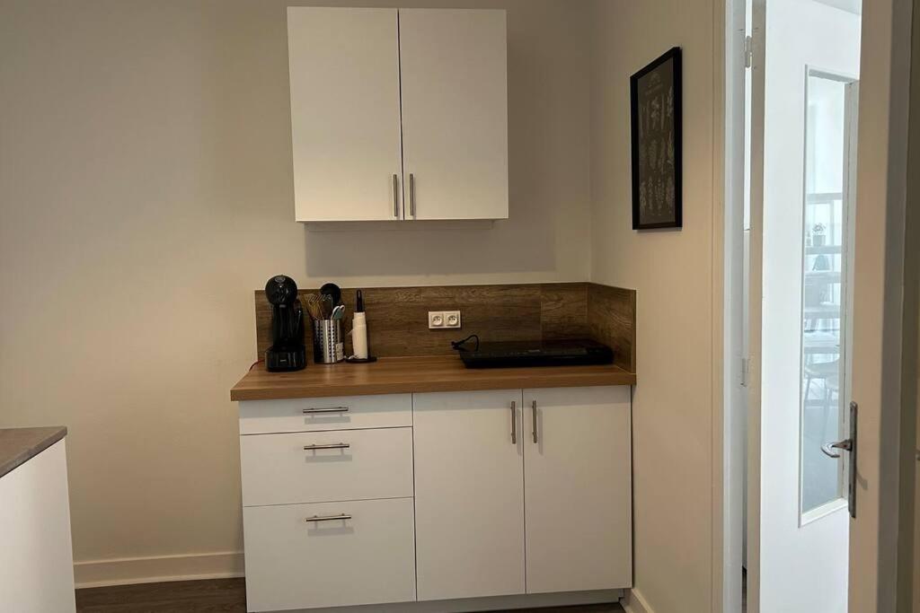 uma cozinha com armários brancos e uma bancada em Appartement cœur de ville em Châtillon-sur-Indre