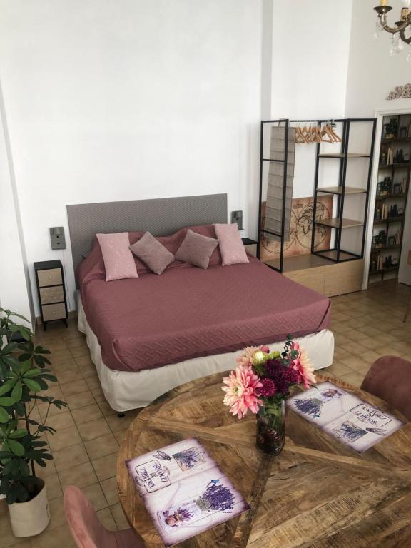 - une chambre avec un lit et une table fleurie dans l'établissement Studio au cœur d'Avignon intra-muros, à Avignon
