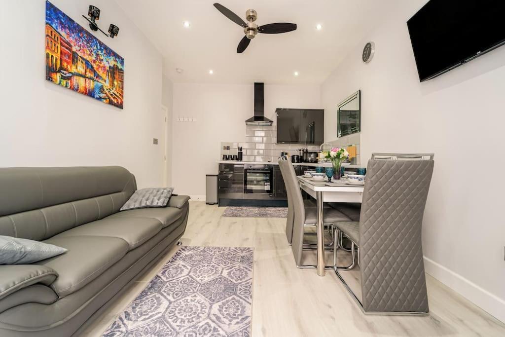 ein Wohnzimmer mit einem Sofa und einem Tisch in der Unterkunft Stylish 2Bedroom flat near train station in London in Seven Kings
