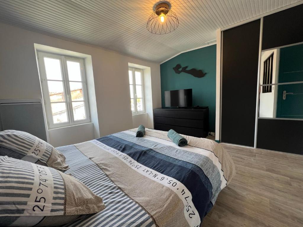 ein Schlafzimmer mit einem großen Bett und einem Spiegel in der Unterkunft Le Phare du Bout du Monde - Logement proche du port in La Flotte