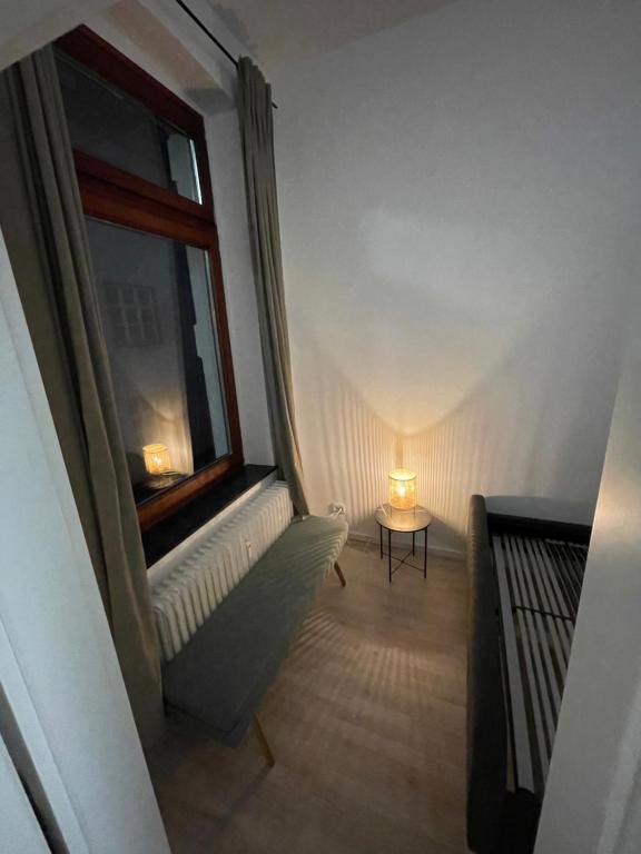 a room with a window and a table with a lamp at Retro Appartement im Herzen von Köln Deutz in Cologne