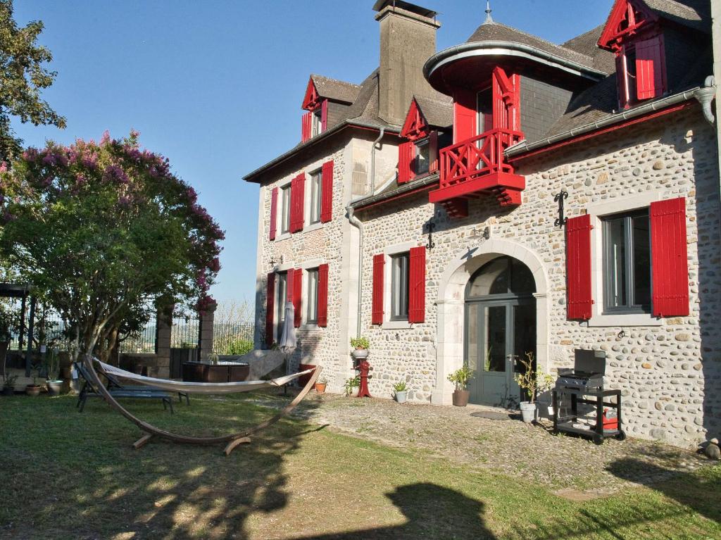 a house with a hammock in front of it at Les Tanalis - Chambres d'hôtes & Gîte in Gurs