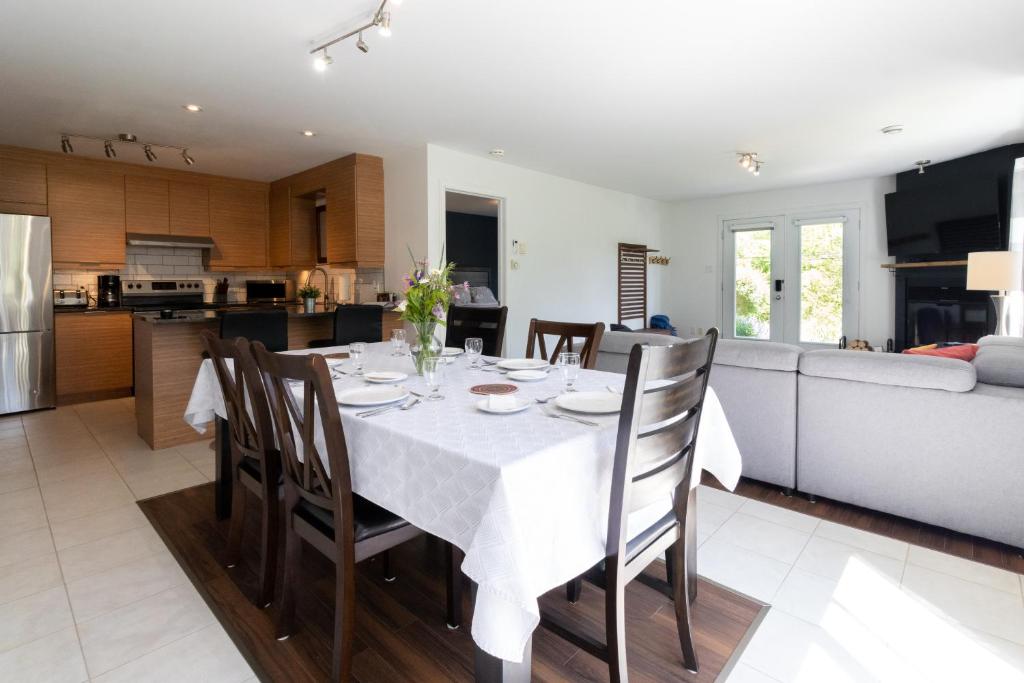 a dining room and kitchen with a table and chairs at Détente Orford 111 condo/chalet in Orford