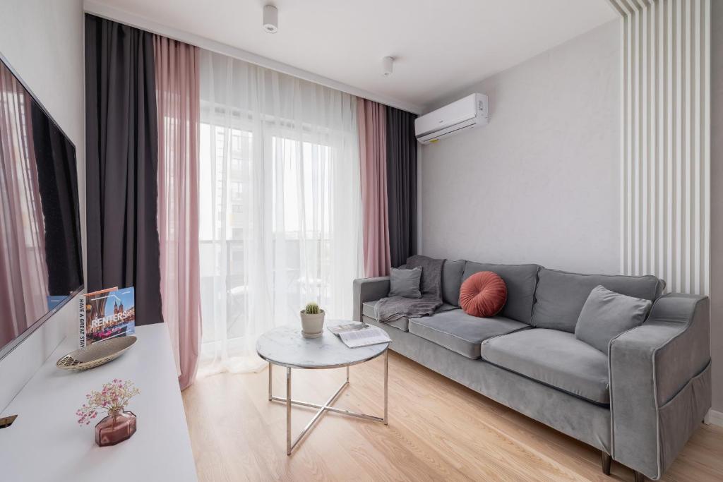 a living room with a gray couch and a table at Vetulaniego Apartment with Air Conditioning & Parking by Renters Prestige in Krakow