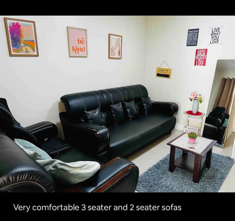 sala de estar con sofá de cuero negro y mesa en Cozy and Spacious With a view and parking, en Antipolo
