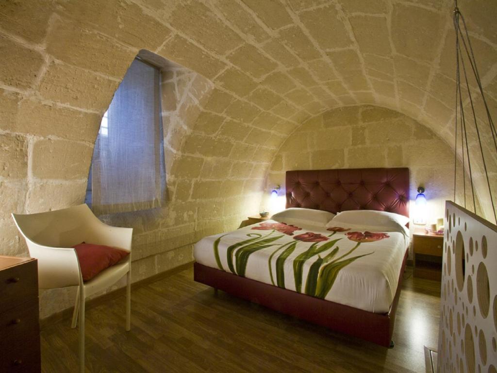 マテーラにあるLa Perla dei Sassiの石壁のベッドルーム1室