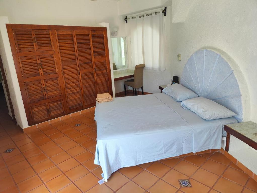 1 dormitorio con cama blanca y puerta de madera en Villa Isabel, en Tangolunda