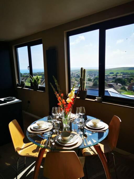 a dining room table with chairs and a table with glasses at Luxury Apartment Brighton and South Downs National Park, Free Parking, animals on request - daily fee in Brighton & Hove