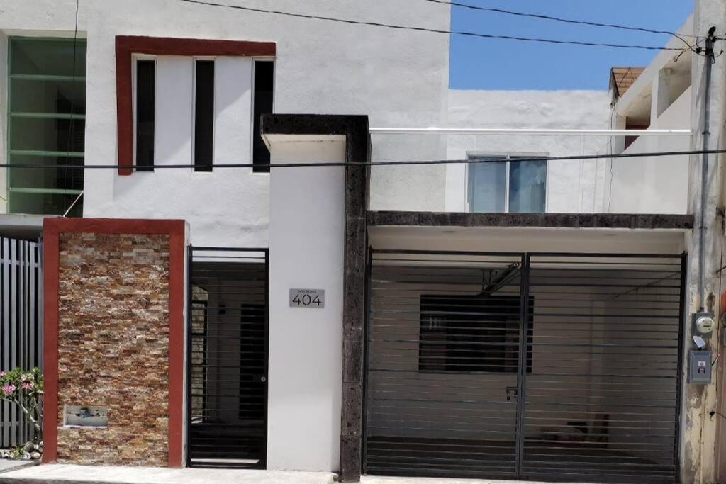 a building with two garage doors in front of it at Amplia Casa/Residencia a 15 Minutos de playa Miramar y Altama in Tampico