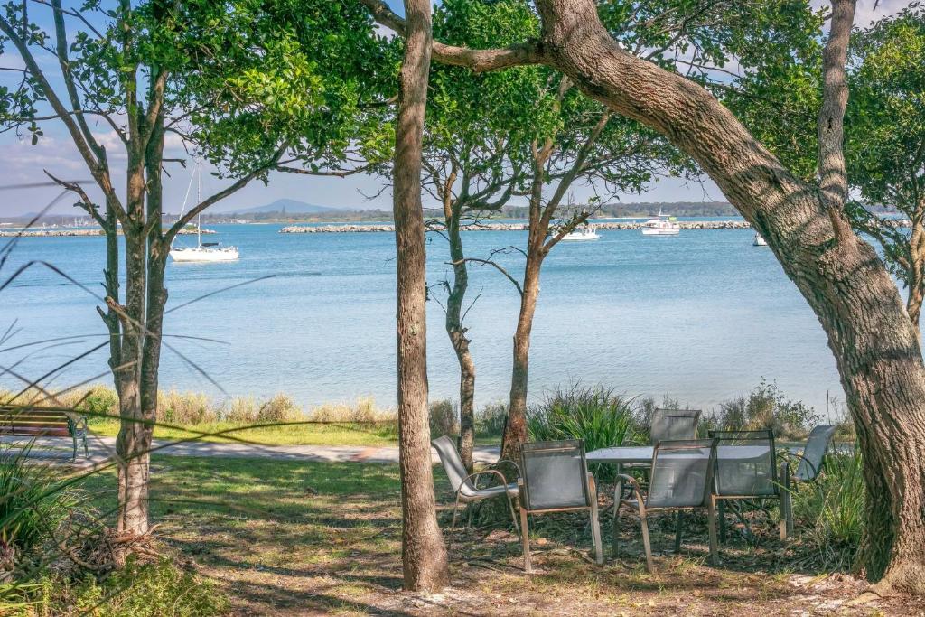 a table and chairs with a view of the water at The Point in Iluka