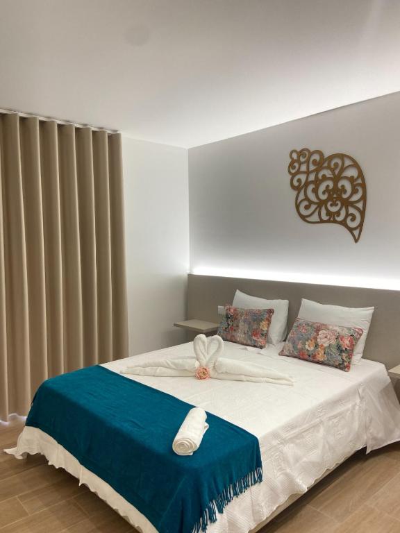 a bedroom with a bed with a blue and white blanket at Plátanos & River Apartments by Lethes Legacy in Ponte de Lima