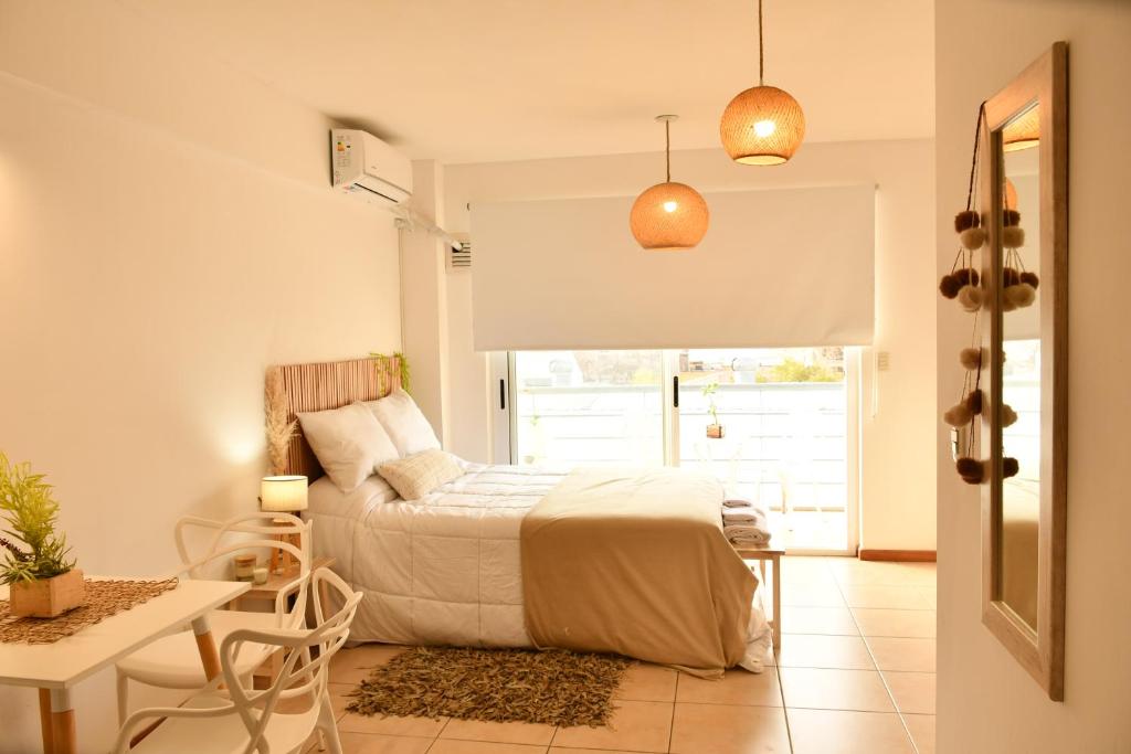 Un dormitorio con una cama, una mesa y un escritorio. en tu dpto en ROSARIO, en Rosario