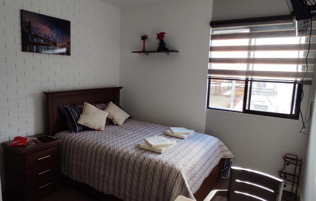 a bedroom with a bed with two towels on it at Monoambiente totalmente equipado y centrico in Cochabamba