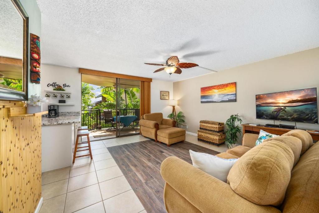 - un salon avec un canapé et un ventilateur de plafond dans l'établissement Big Island Kona Makai 4205 condo, à Kailua-Kona