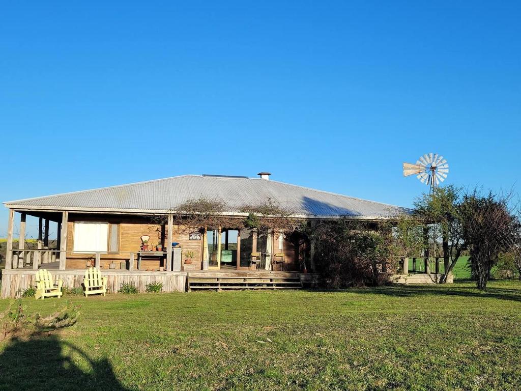 uma casa velha com uma palmeira no quintal em Casa en Las Perdices, Carmelo em Carmelo