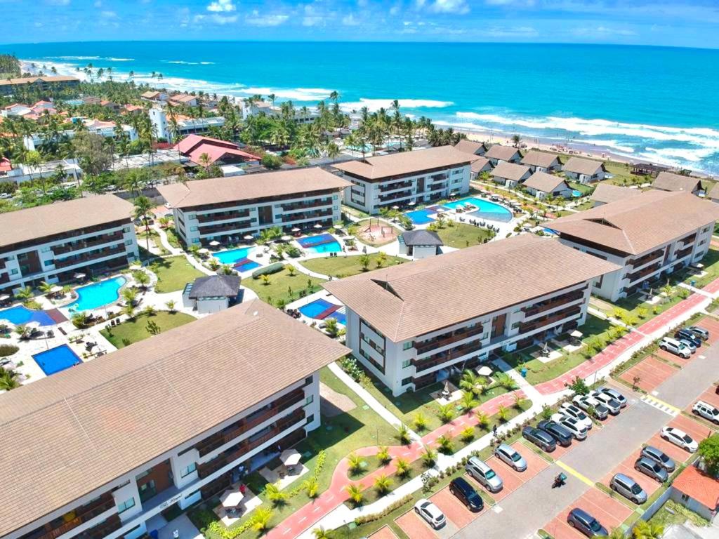 an aerial view of a resort with the ocean at Cupe Beach Living - Royal 206 in Porto De Galinhas