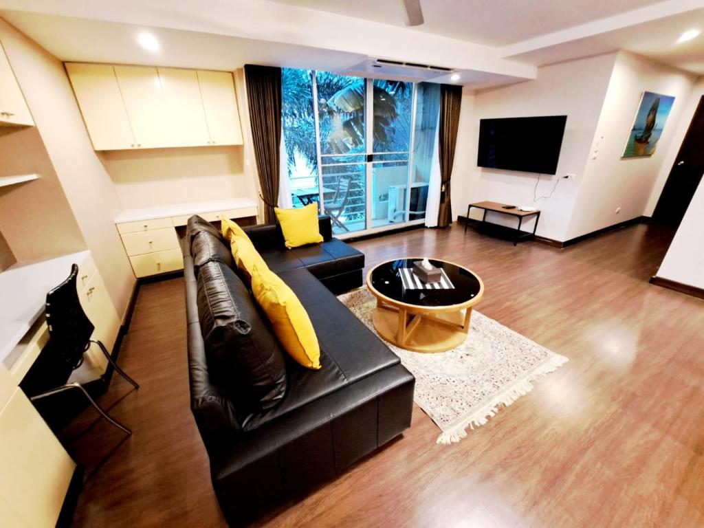 - un salon avec un canapé noir et une télévision dans l'établissement Bangkok Downtown 2bedrooms3bth Near Asoke Btsmrt No1, à Bang Kapi