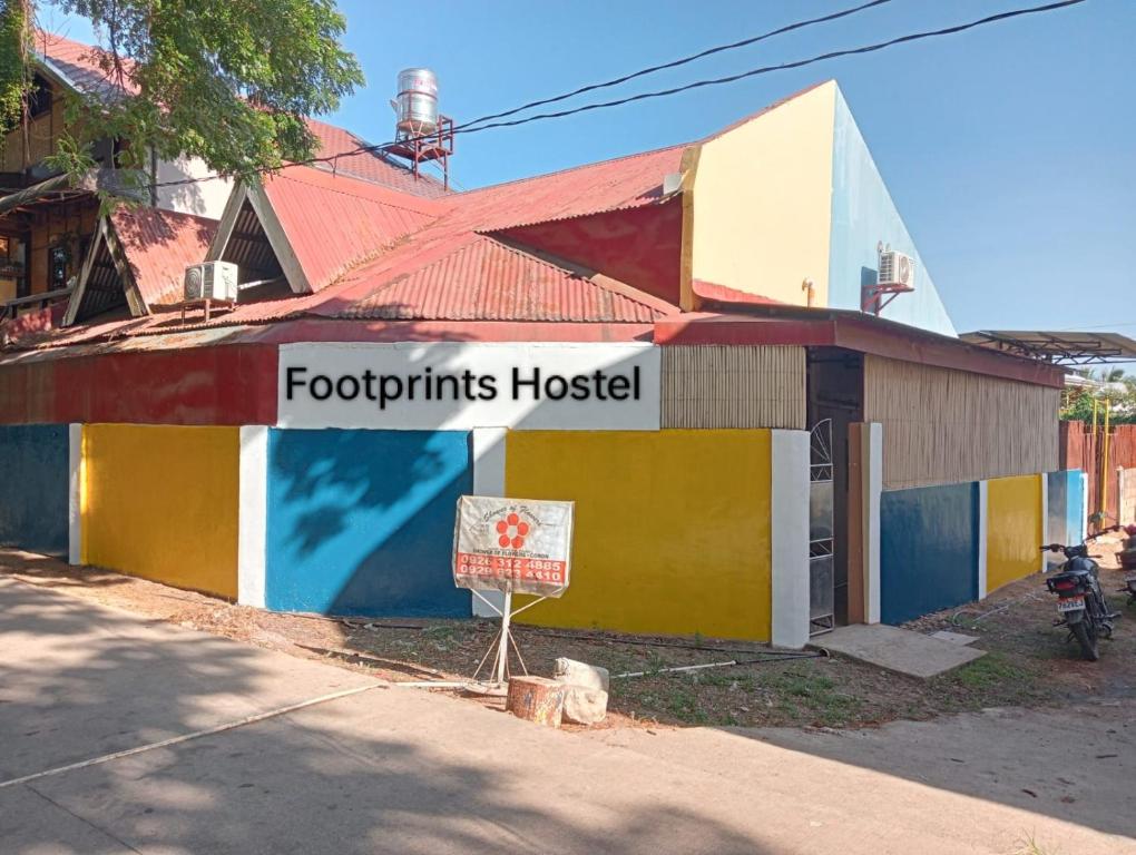 a building with a sign that reads footprints hospital at Footprints Hostel in Coron