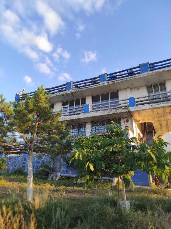 un edificio con un árbol delante en Dede Sebo Çay Bahçesi + Camping, en Doğubayazıt