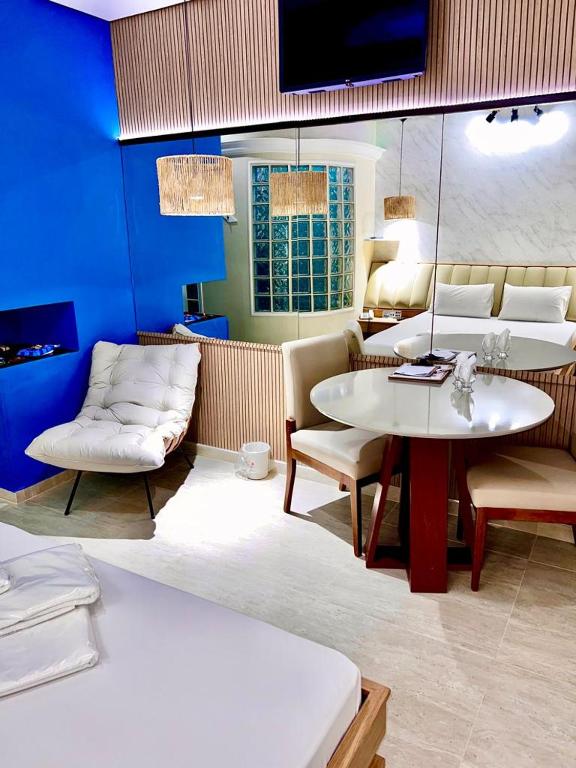 a room with a couch and a table and chairs at Hotel Tennessee in Bragança Paulista